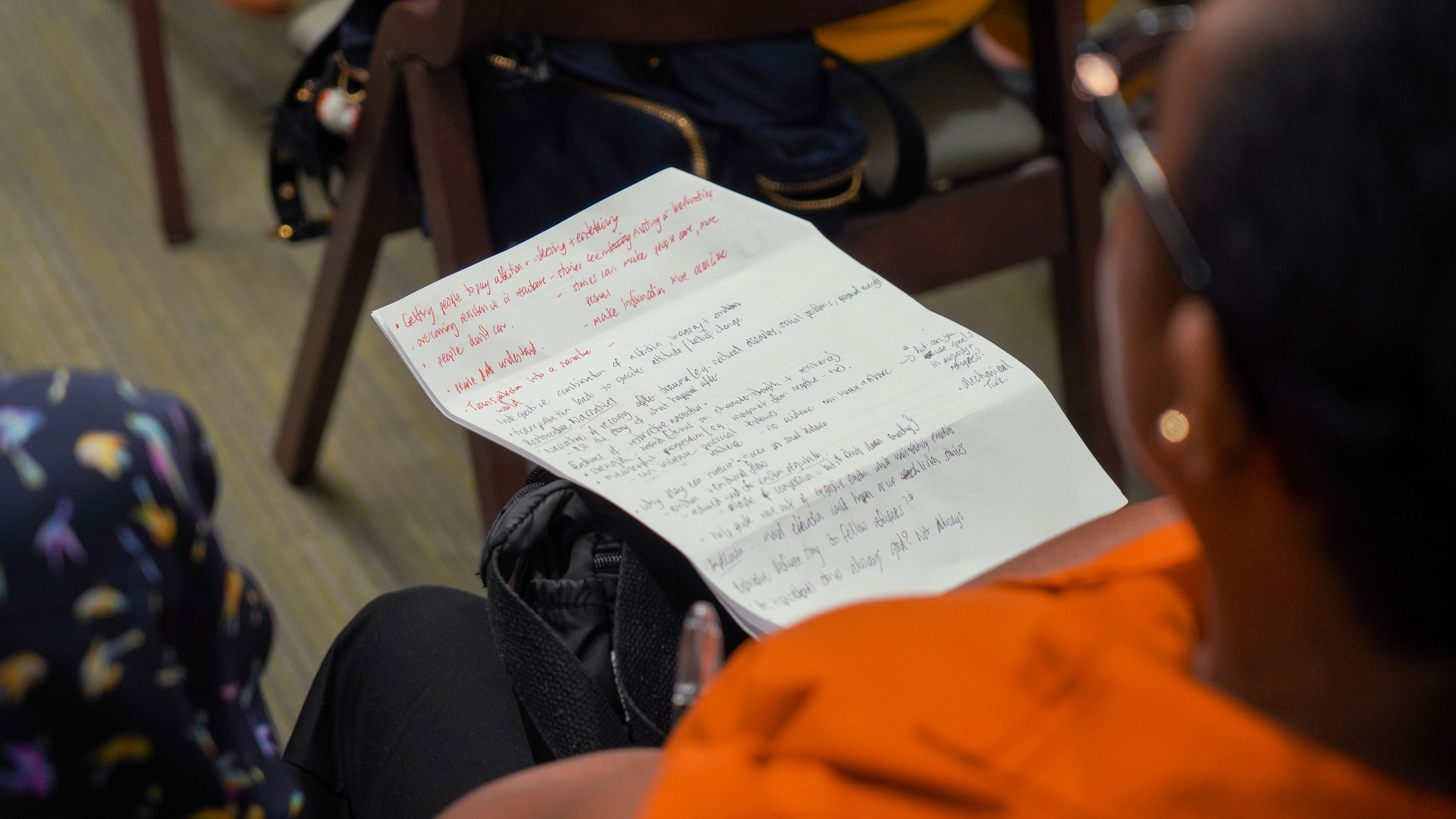 selective focus photography of people sitting on chairs while writing on notebooks