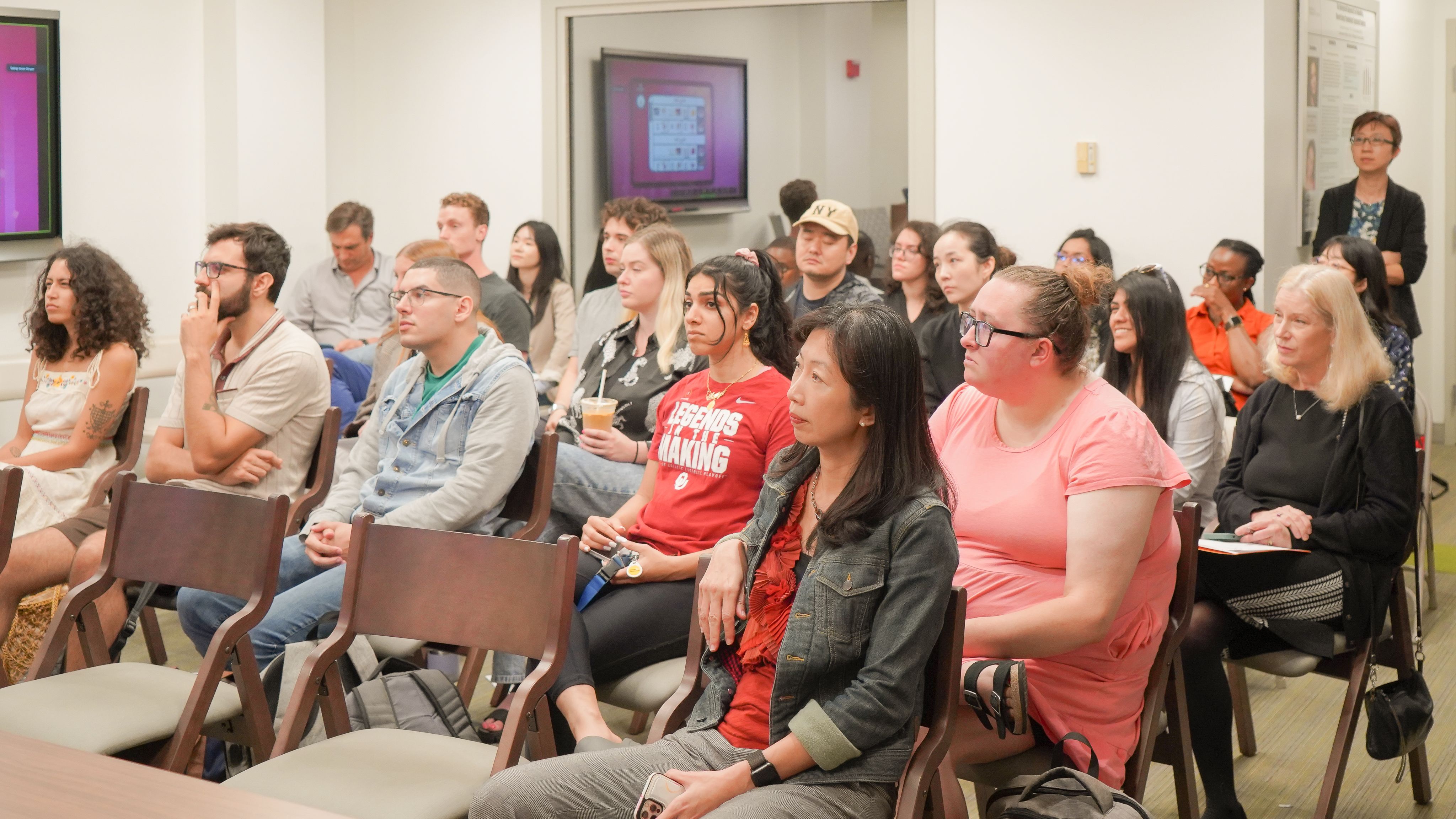 MacBook turned on beside clear drinking glass